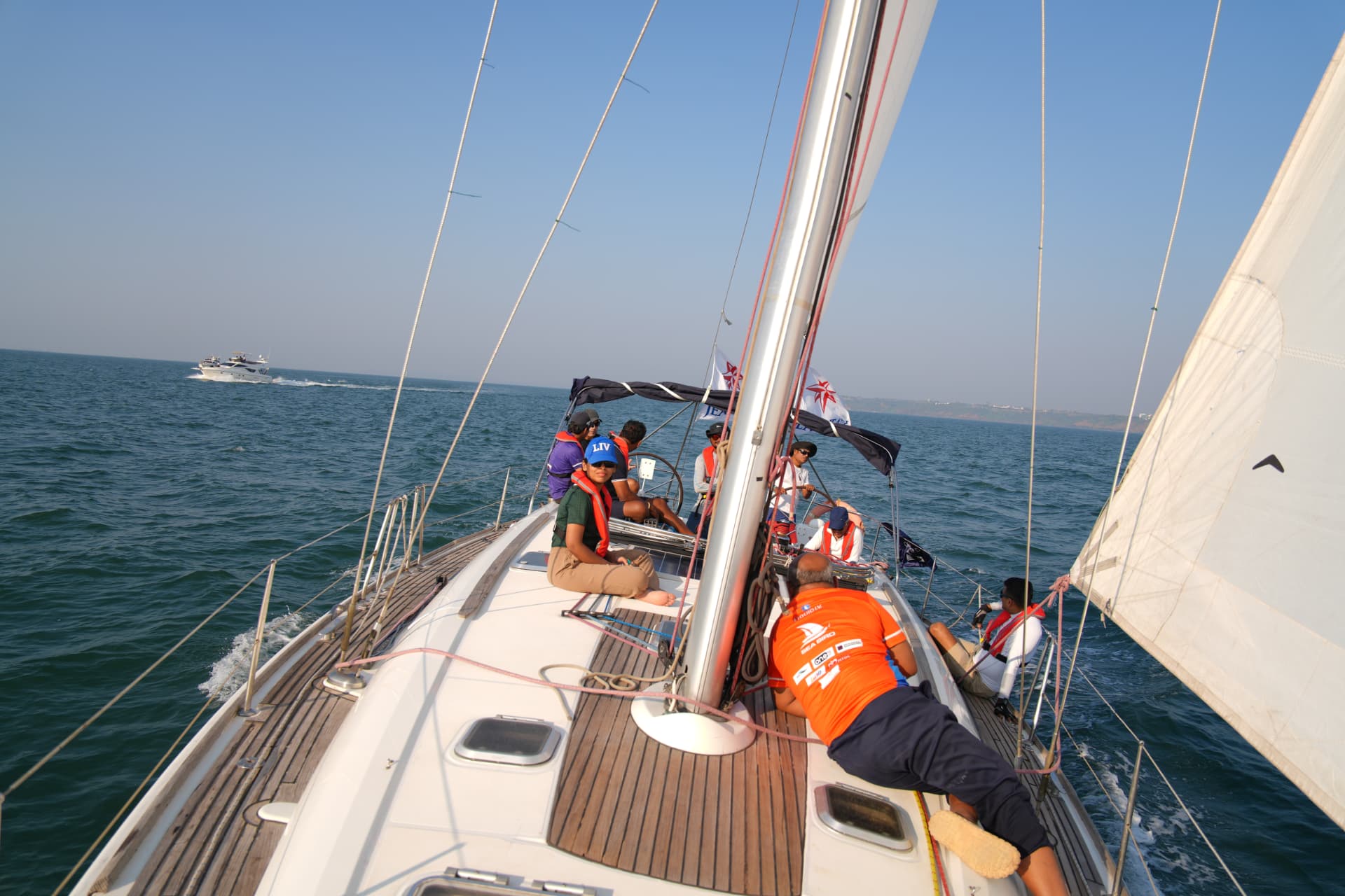 Crew spread along the foredeck of an Ocean Gold keelboat during Season I