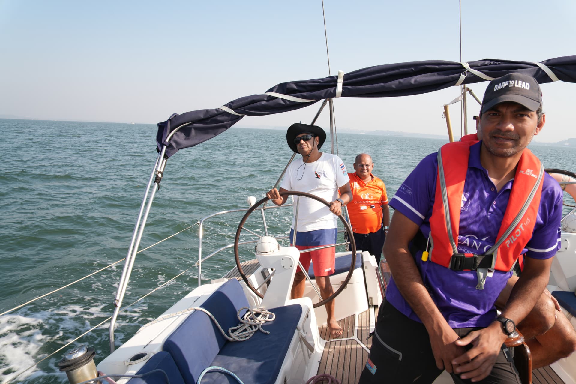 Skipper steering an Ocean Gold yacht with crew on deck